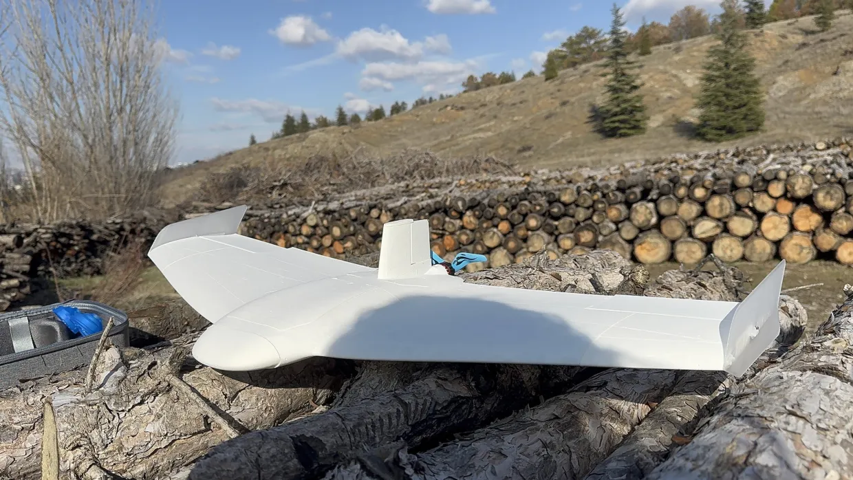 Our competition flying wing on a log pile in a field